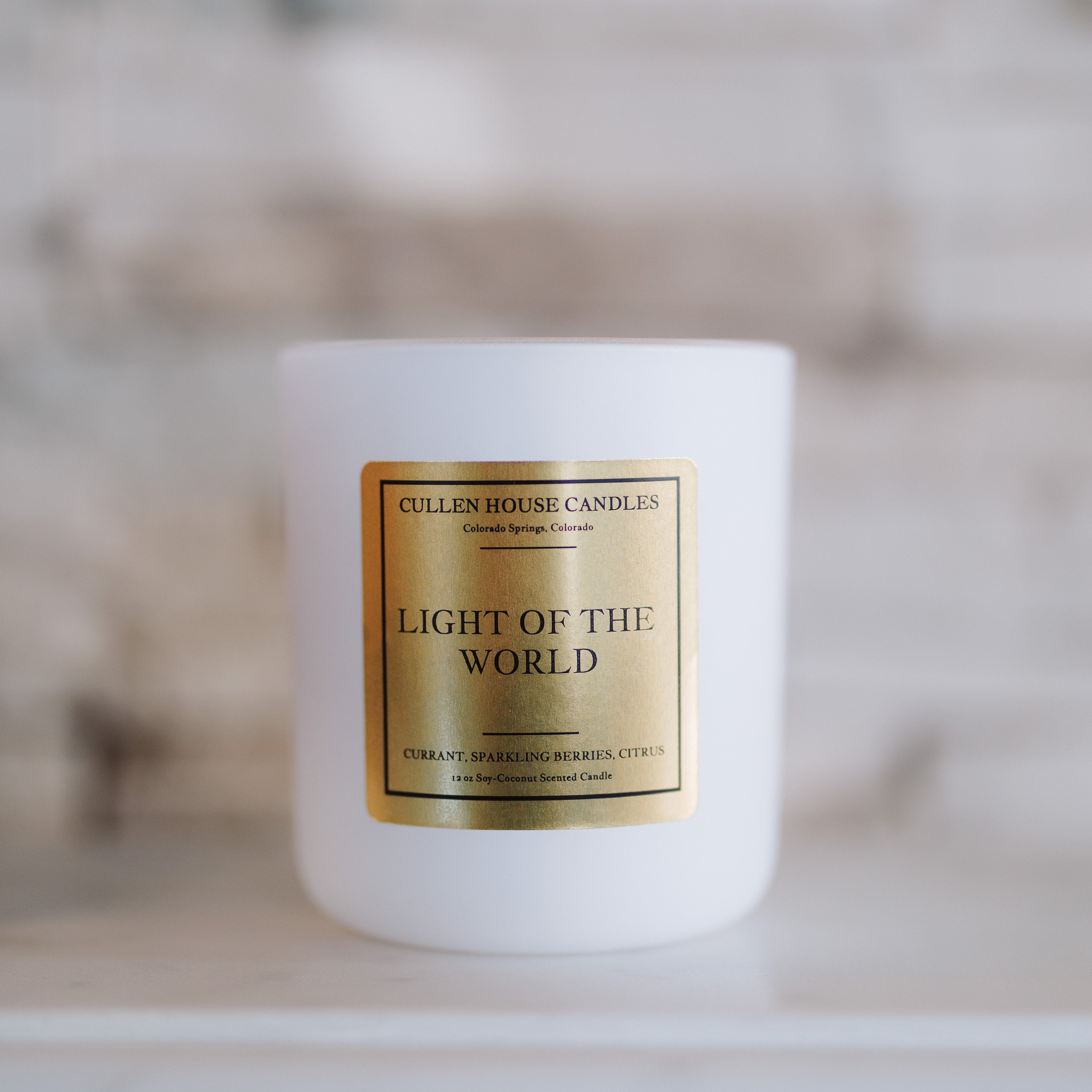 Candle with a gold label on a white surface