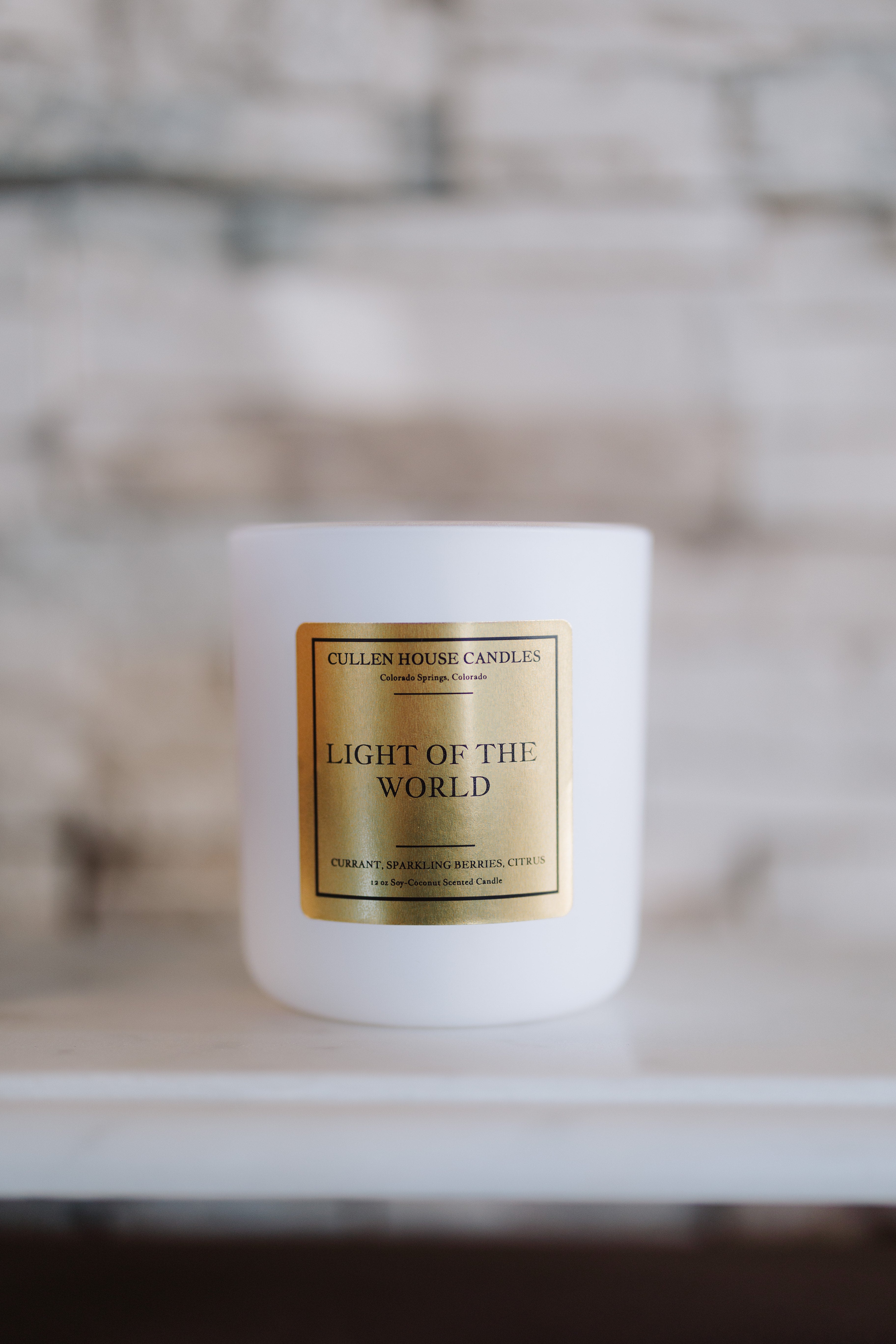 Candle with a gold label on a white surface
