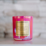Pink candle with a label on a marble surface