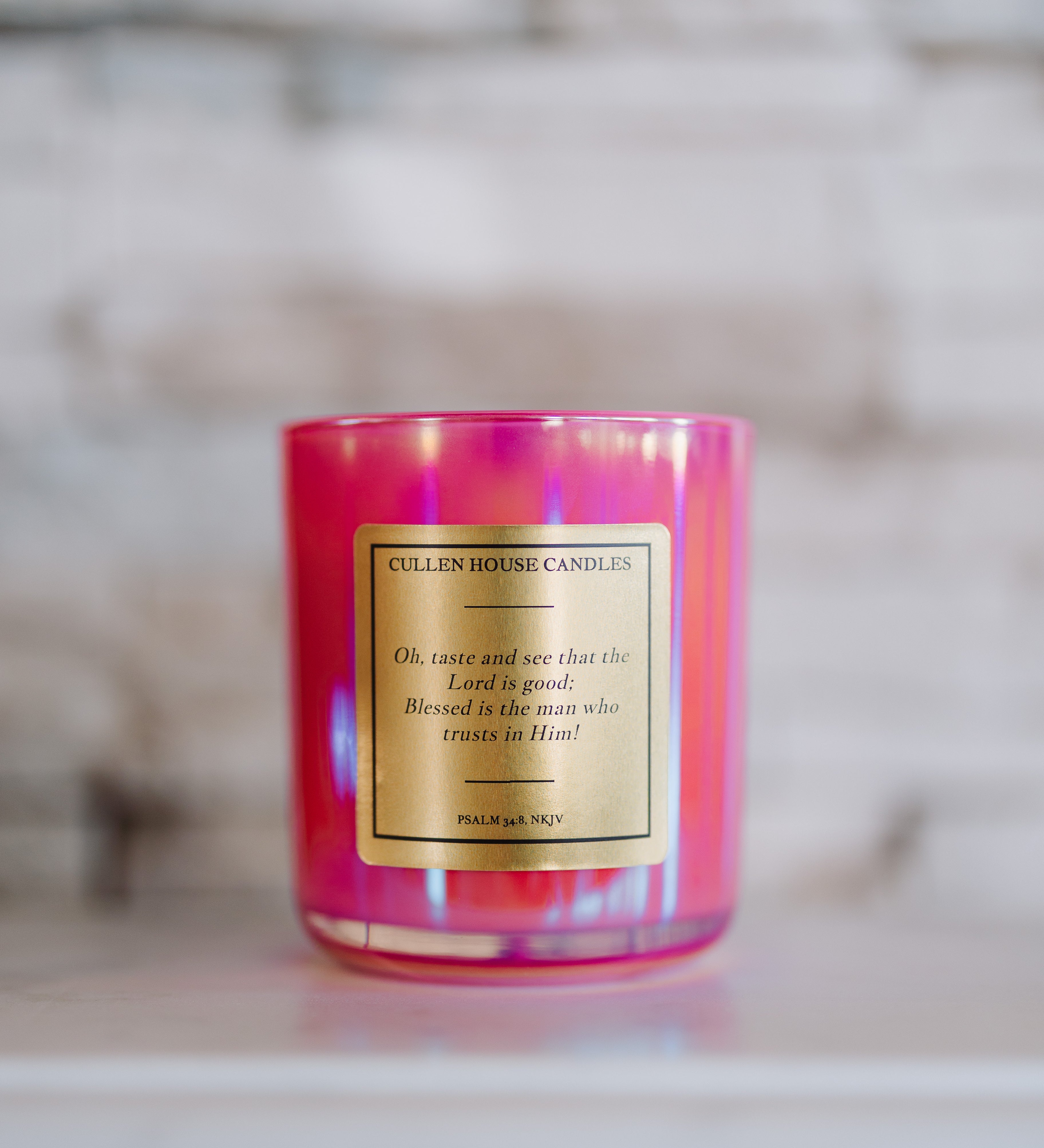 Pink candle with a label on a marble surface