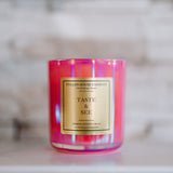 Pink candle with a gold label on a marble surface