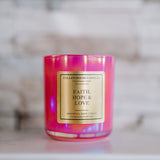 Pink candle with a gold label on a marble surface