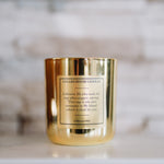 Gold candle with a label on a marble surface