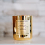 Gold candle with a label on a marble surface