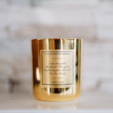 Gold candle with a label on a marble surface