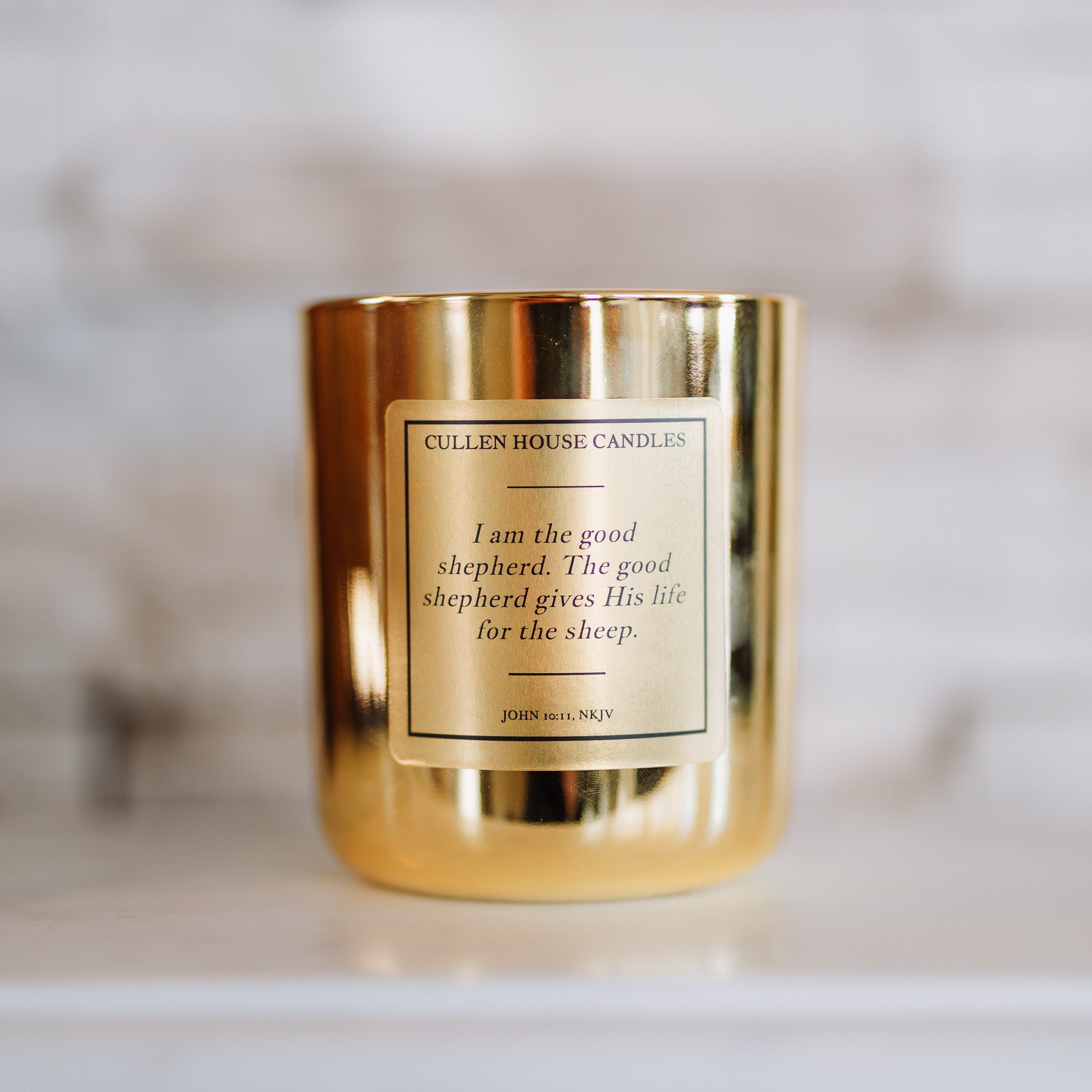 Gold candle with a label on a marble surface