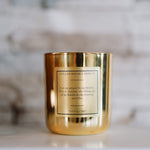 Gold candle with a label on a marble surface