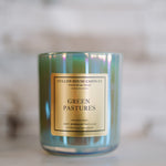 Candle with 'Green Pastures' label on a blurred background