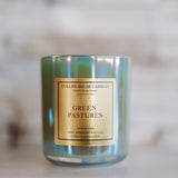 Candle with 'Green Pastures' label on a blurred background