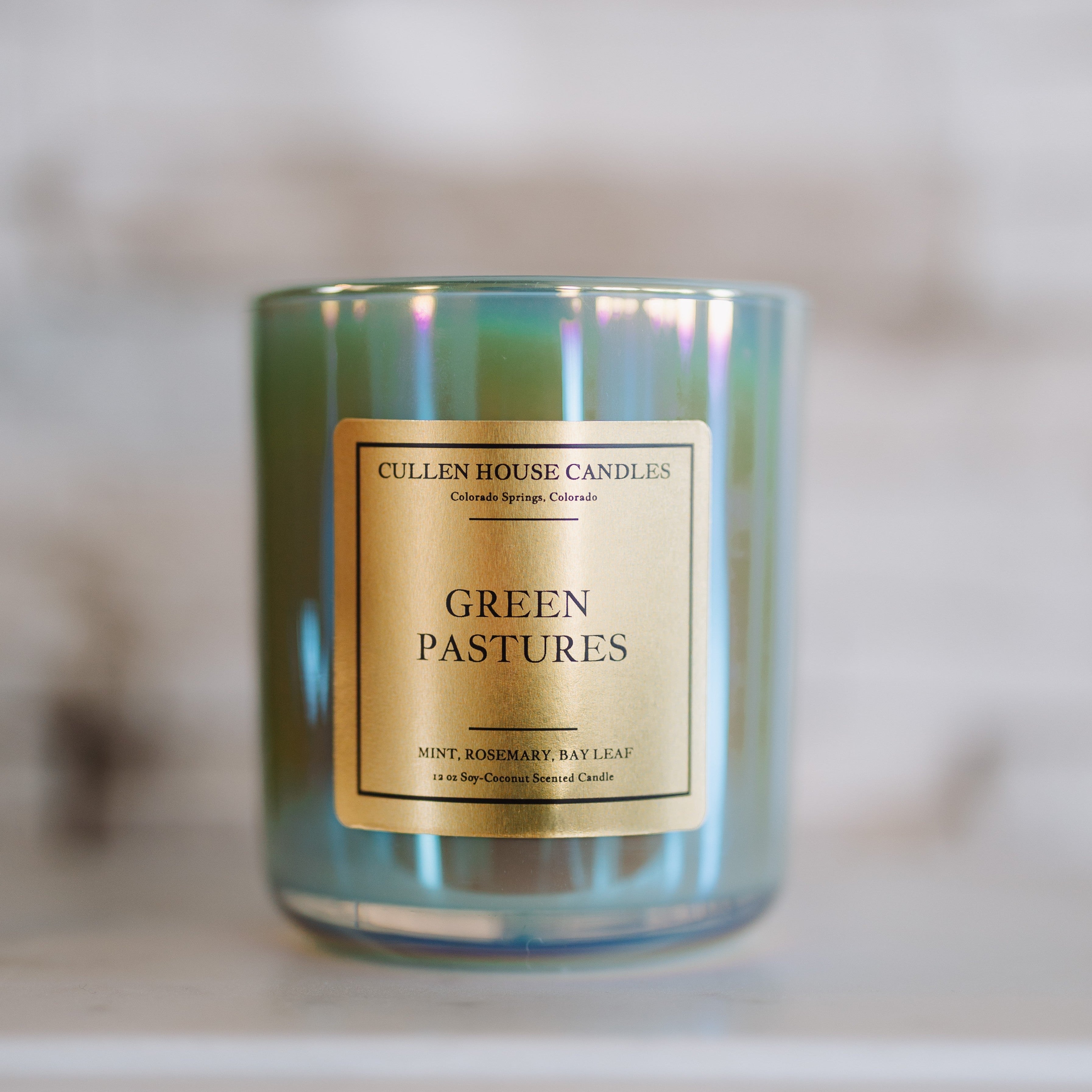 Candle with 'Green Pastures' label on a blurred background