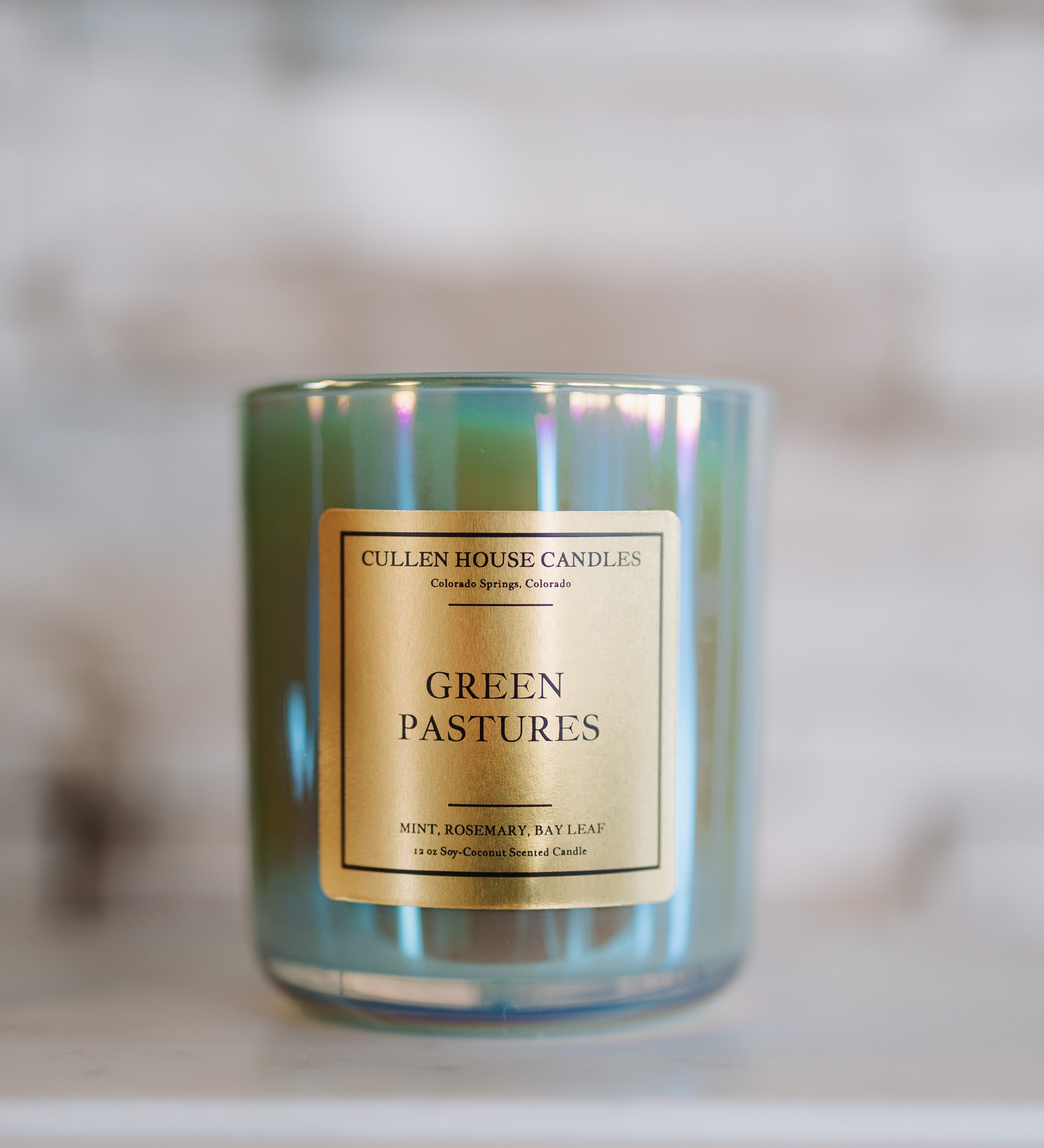 Candle with 'Green Pastures' label on a blurred background