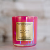 Candle with 'Banquet of Love' label on a reflective surface