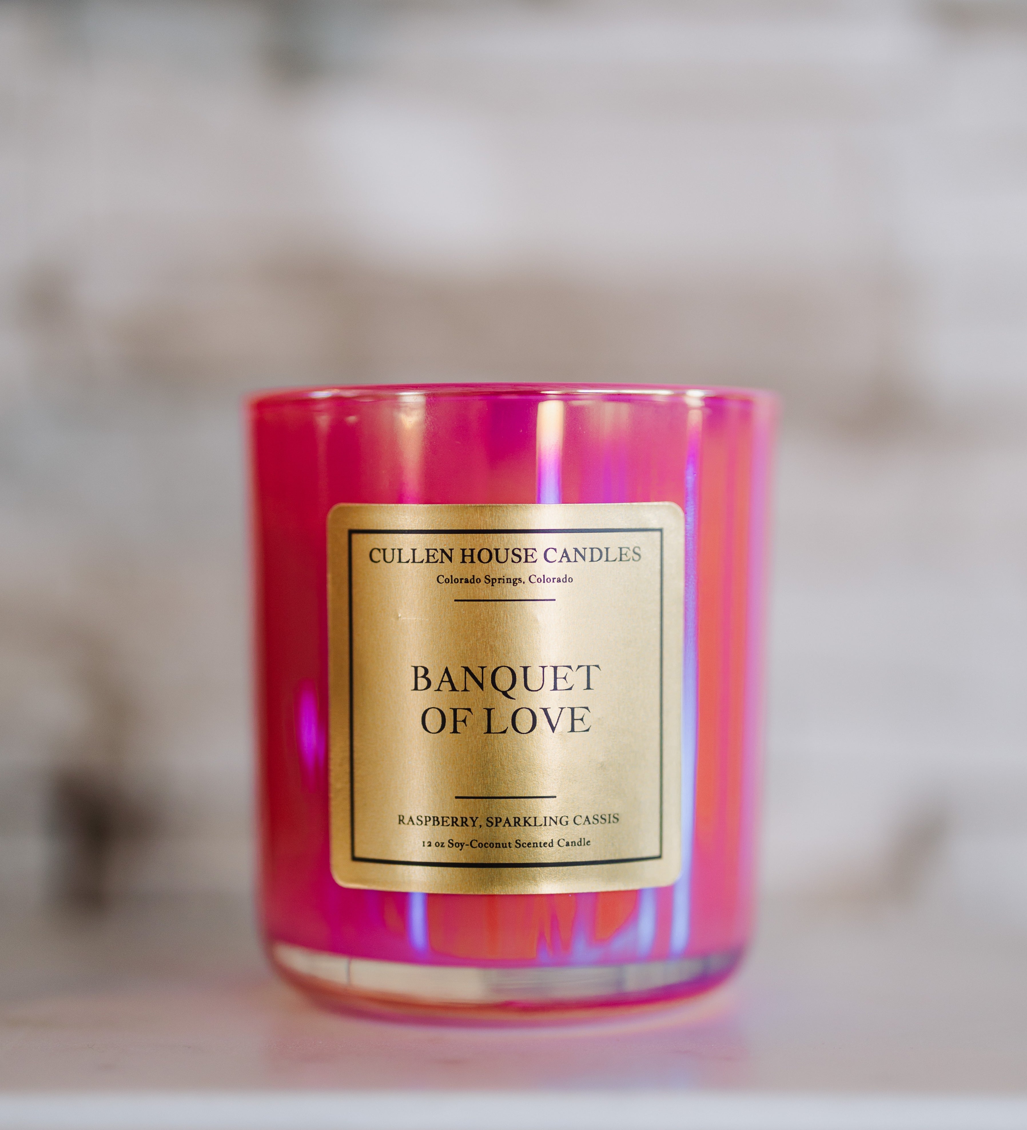 Candle with 'Banquet of Love' label on a reflective surface