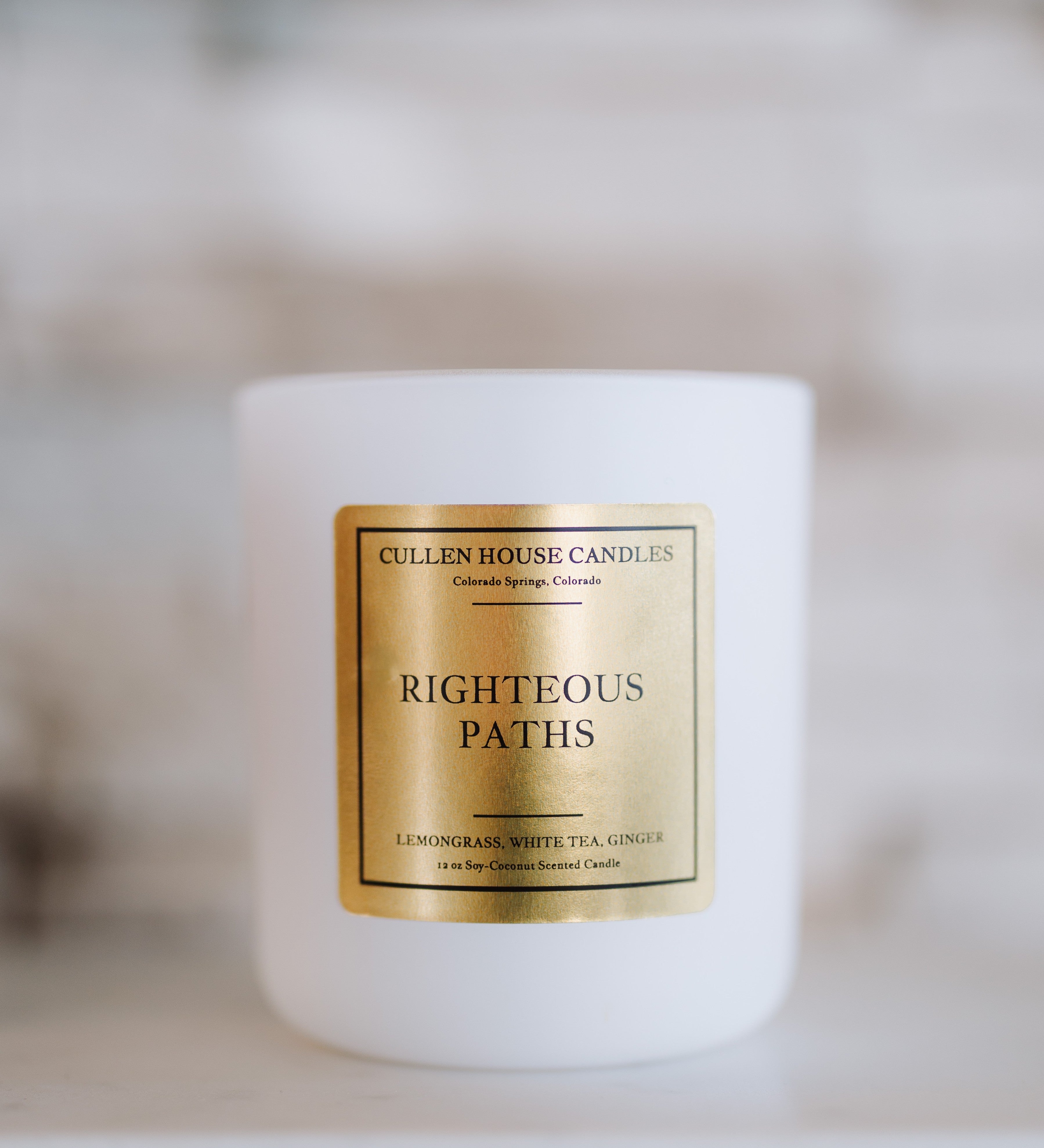 Candle with a gold label on a blurred background