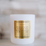 White candle with a gold label on a blurred background