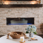 Living room with a white coffee table, decorative items, and a stone fireplace.