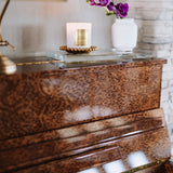 Piano with a candle and decorative flowers on a glass surface