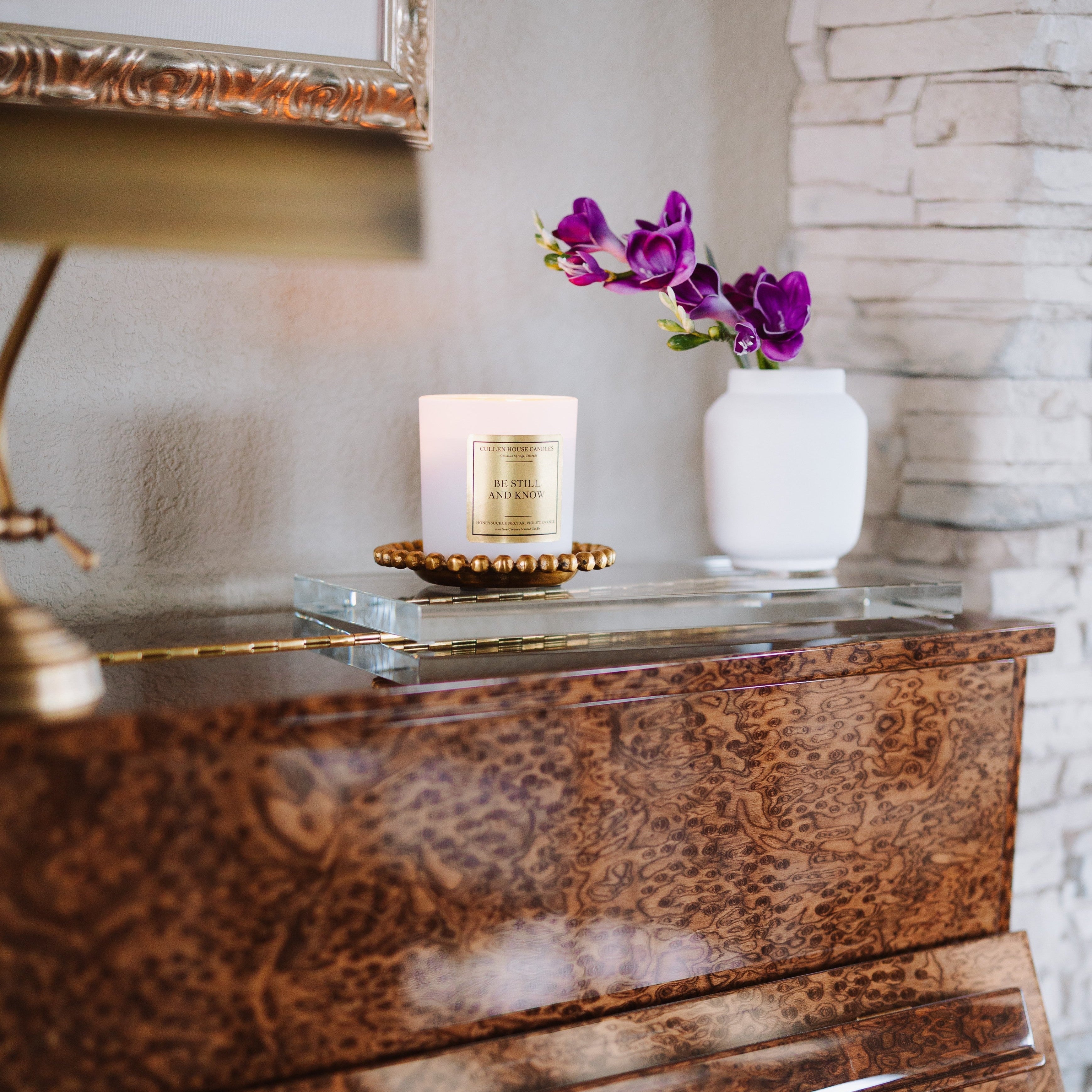 Piano with a candle and decorative flowers on a glass surface