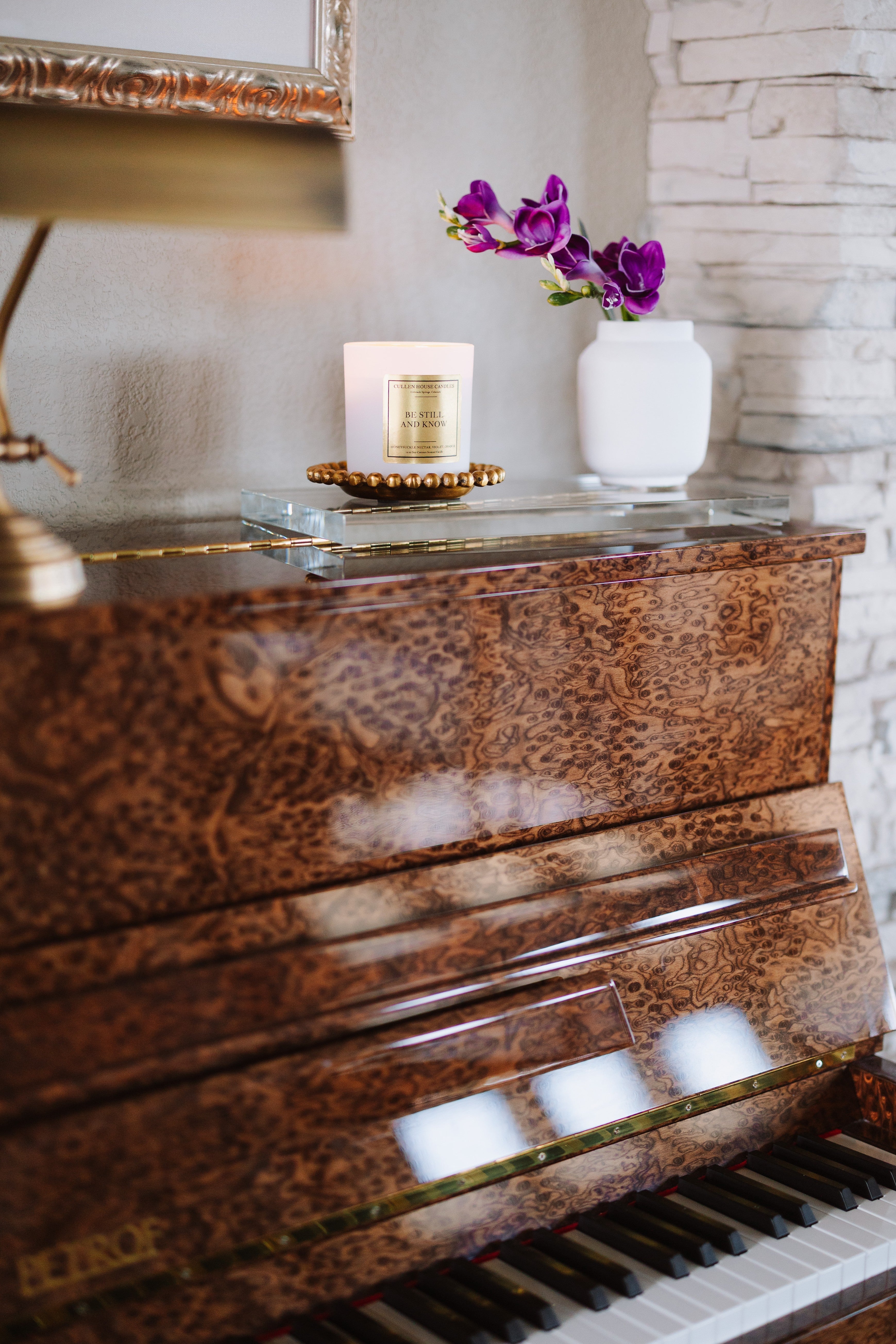 Piano with a candle and decorative flowers on a glass surface