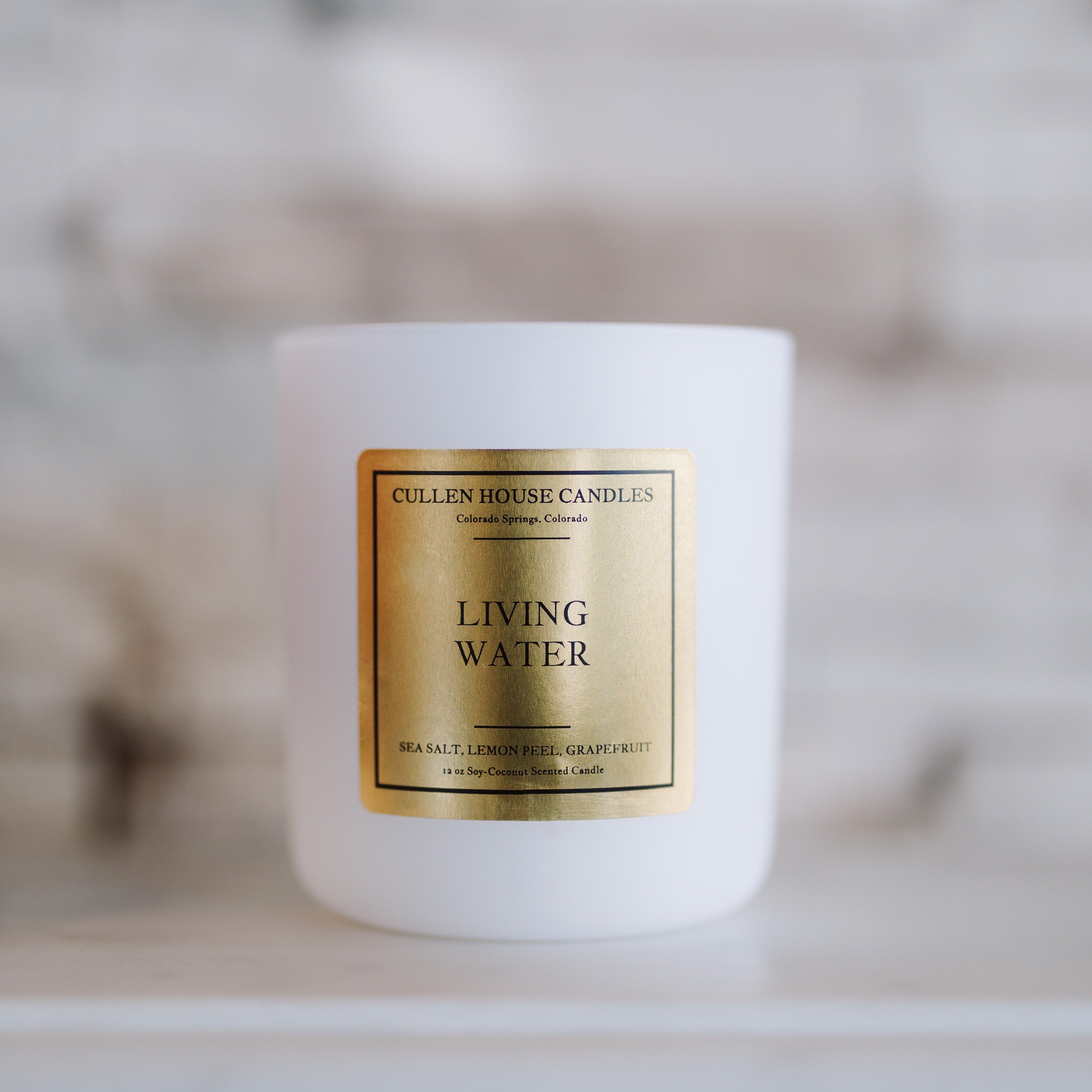 Candle labeled 'Living Water' by Cullen House Candles on a neutral background