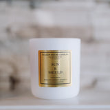 White candle with a gold label on a blurred background