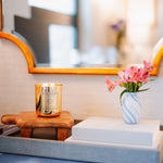 Decorative setup with a candle, flowers, and books on a surface.