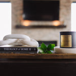 Candle and books on a wooden surface with a blurred background