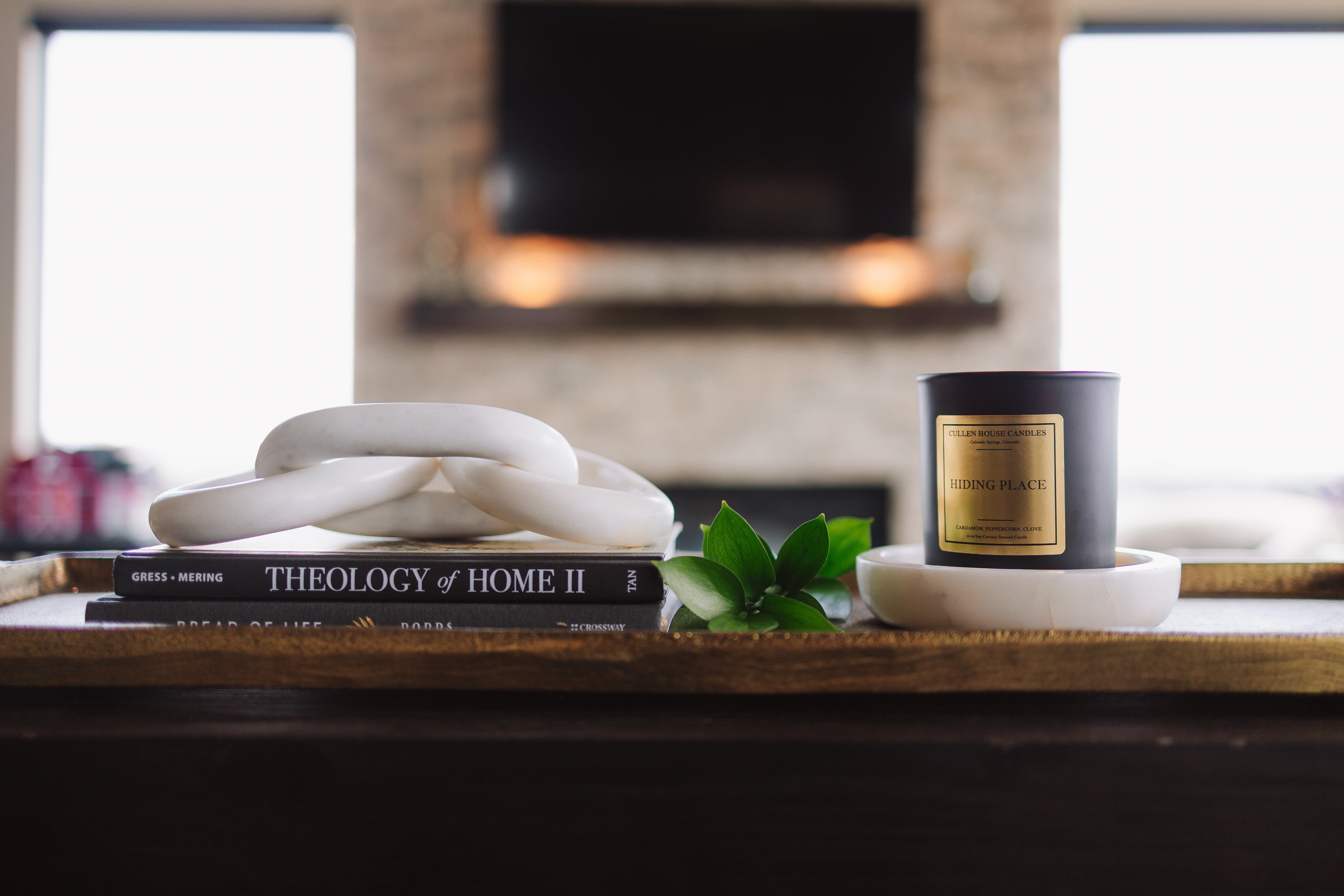 Candle and books on a wooden surface with a blurred background