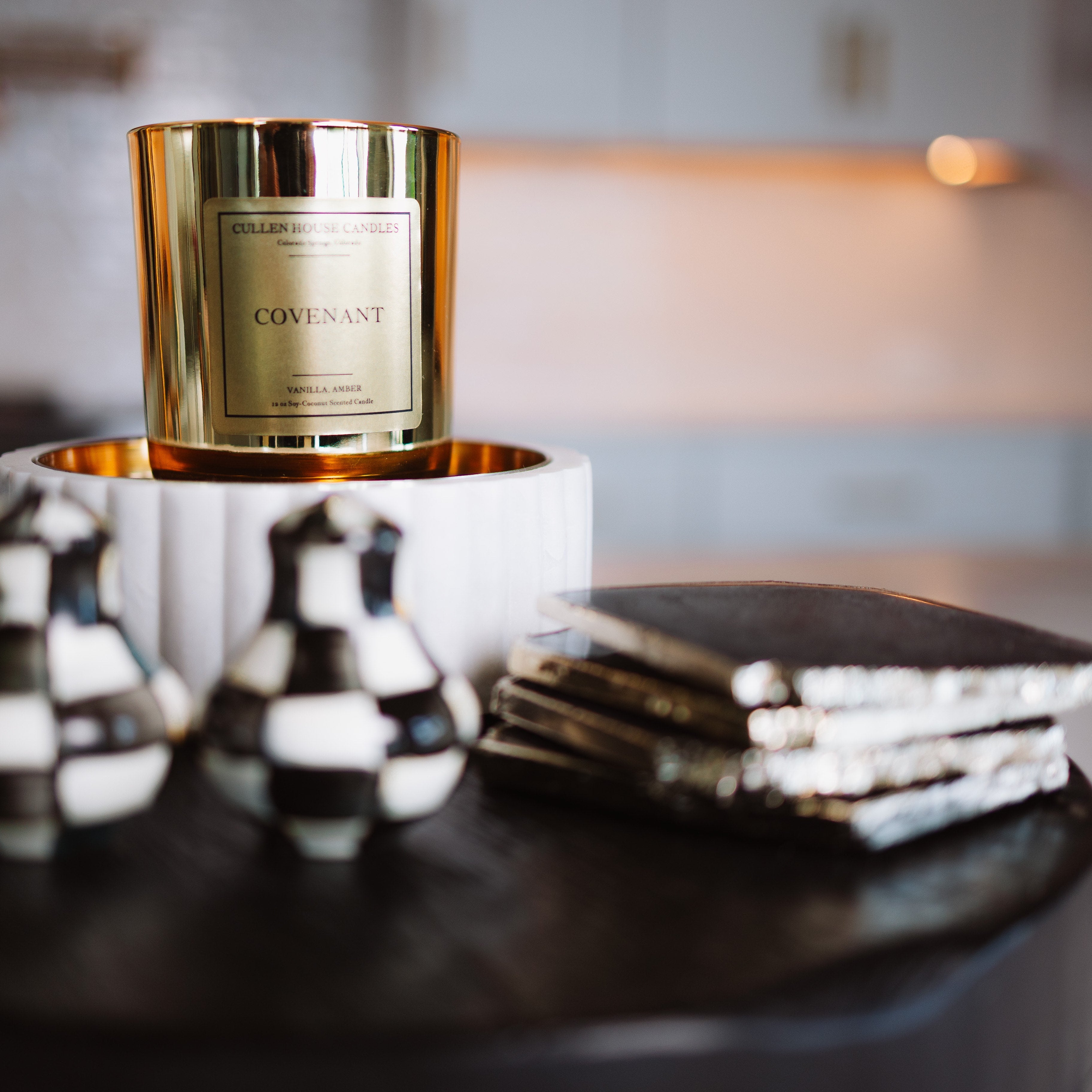 Candle with decorative pot and books on a table