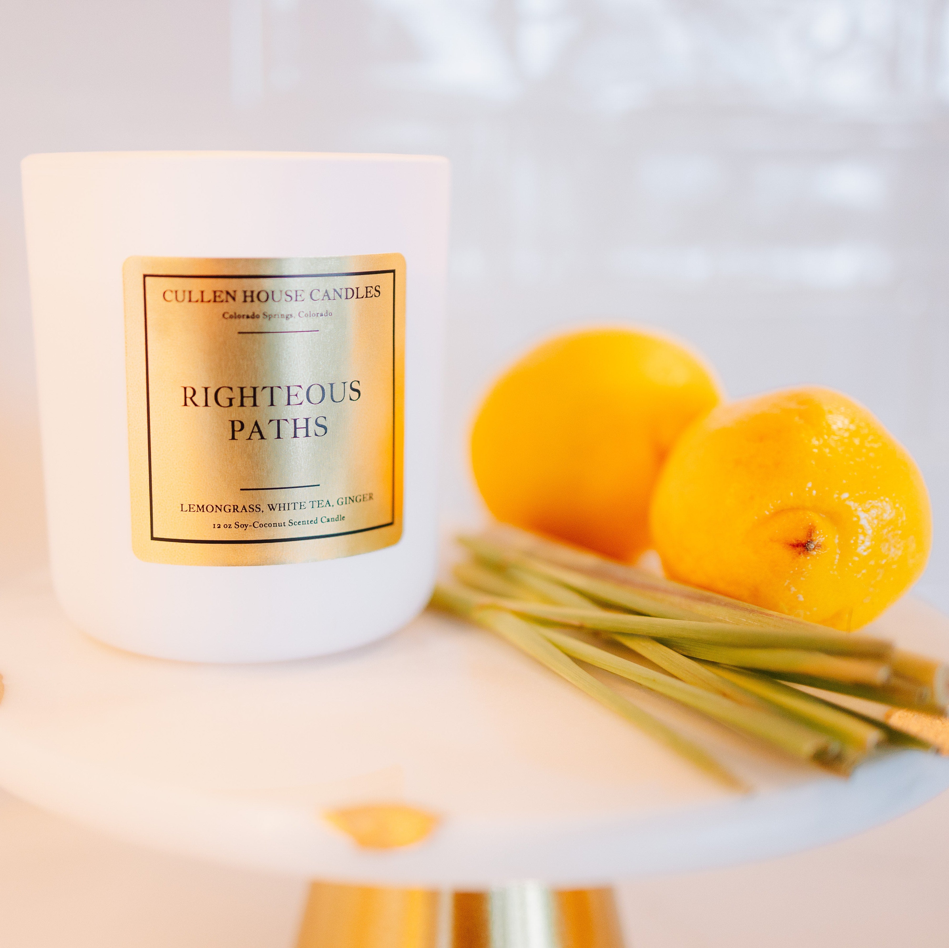 Candle labeled 'Righteous Paths' with lemons on a white surface