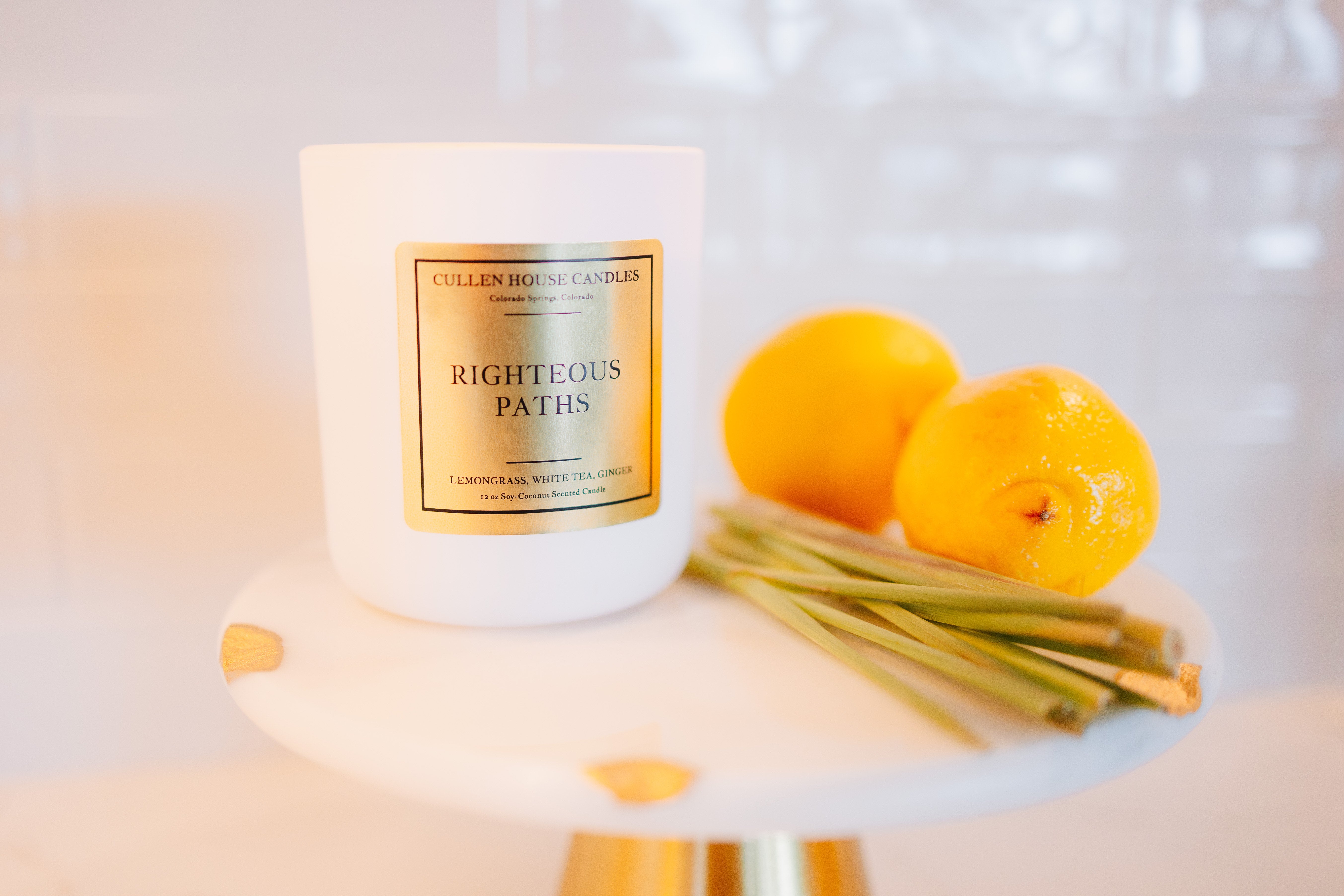 Candle labeled 'Righteous Paths' with lemons on a white surface