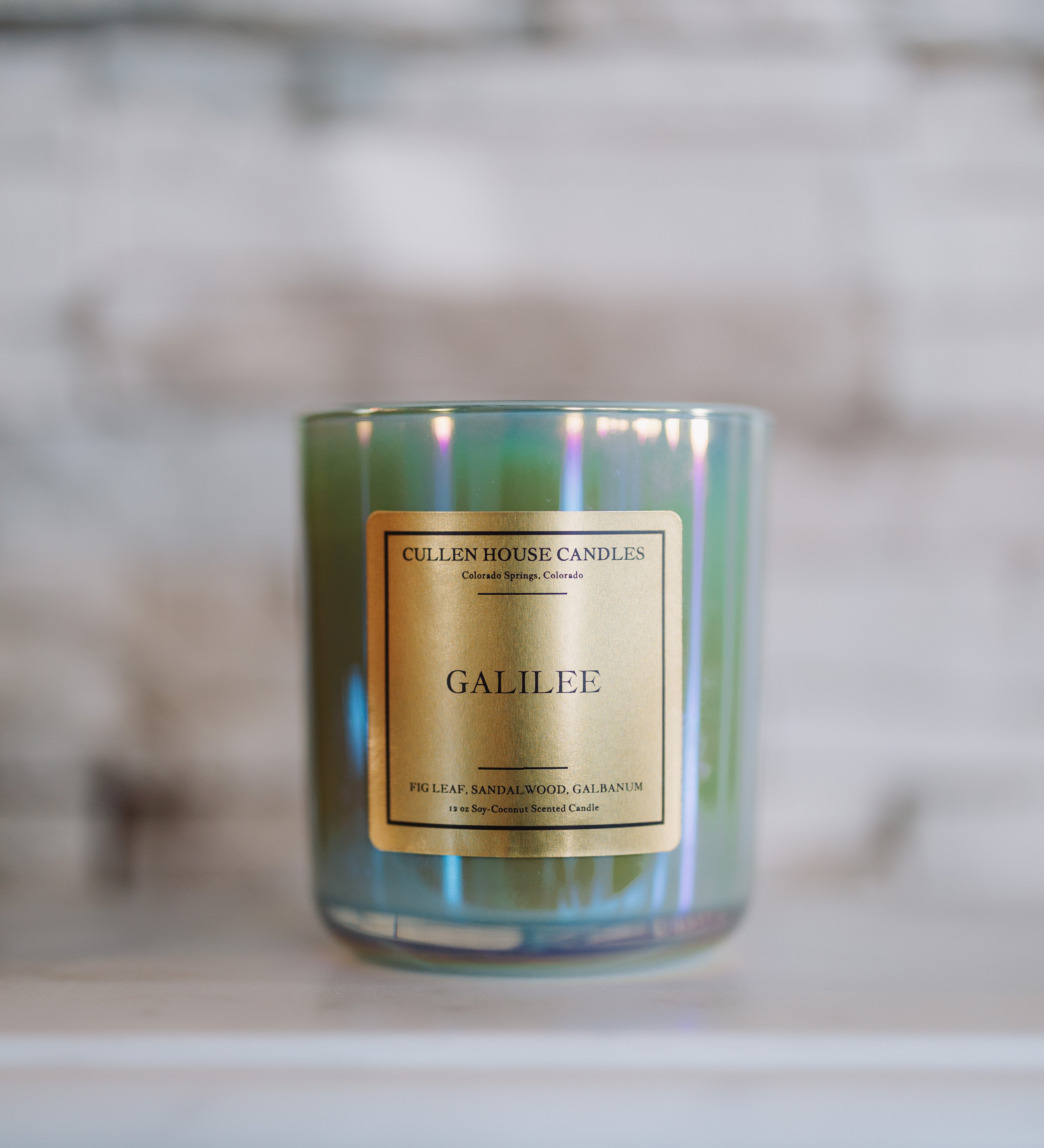 Candle labeled 'Galilee' by Cullen House Candles on a marble surface with a blurred background.