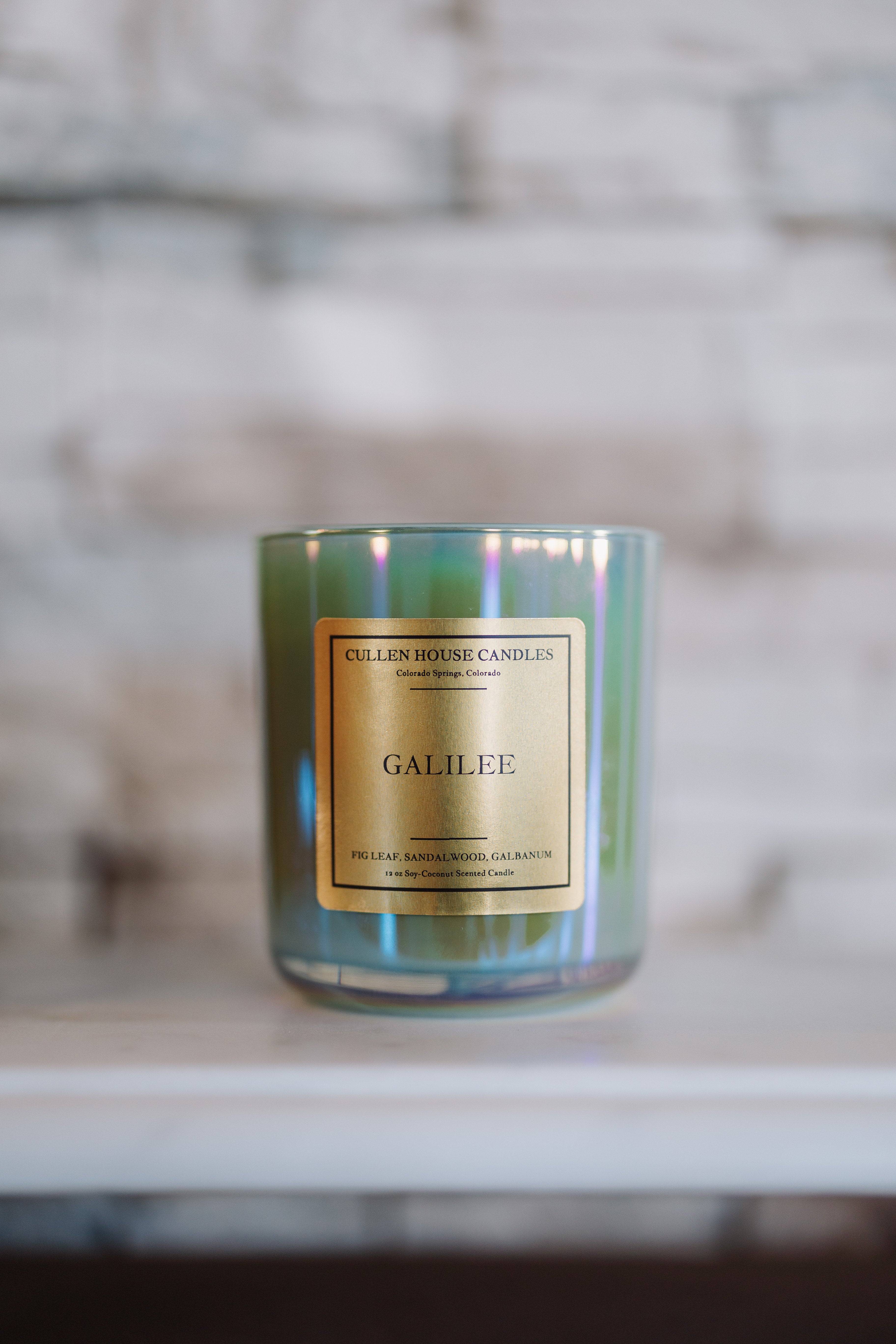 Candle labeled 'Galilee' by Cullen House Candles on a marble surface with a blurred background.
