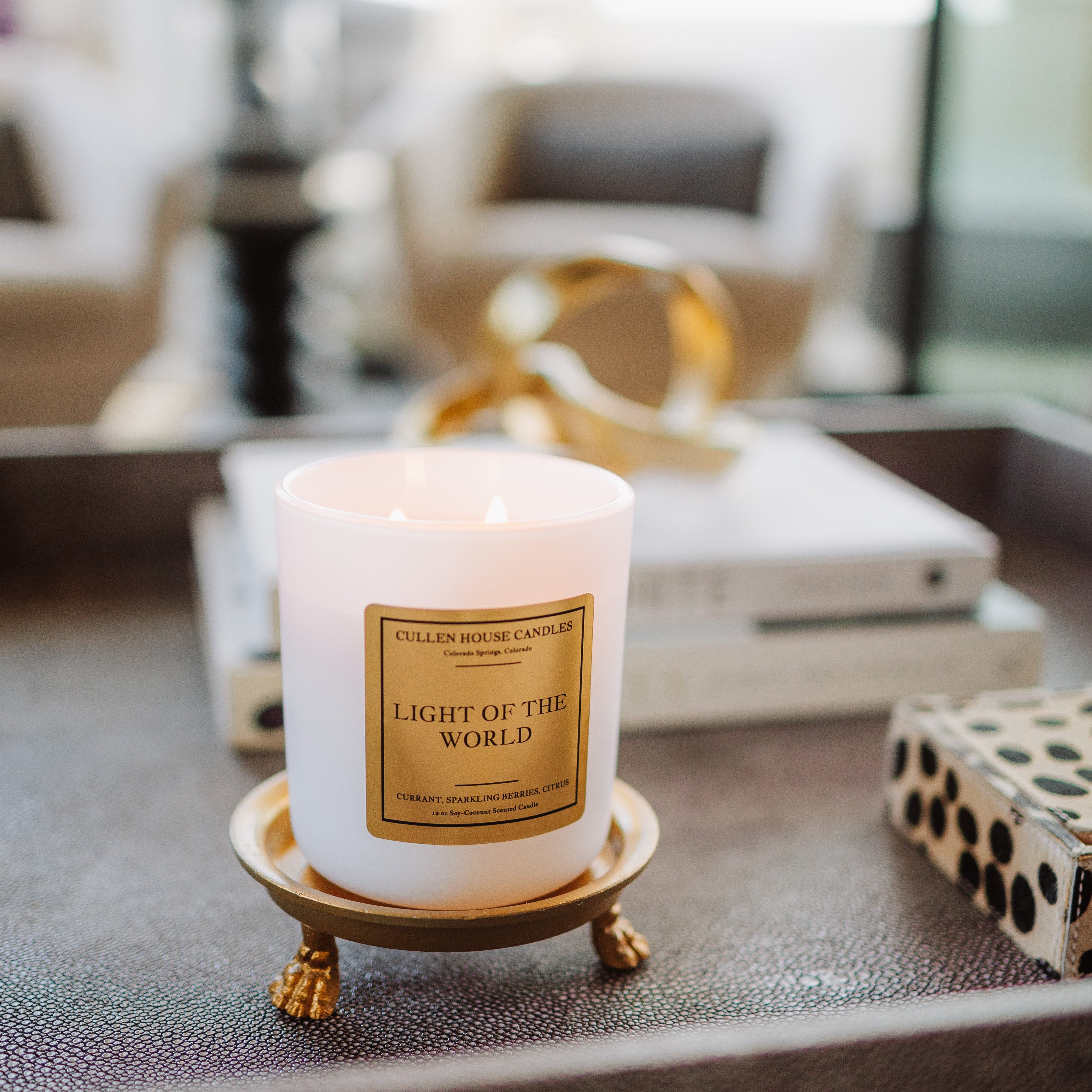 Candle labeled 'Light of the World' on a decorative stand in an indoor setting