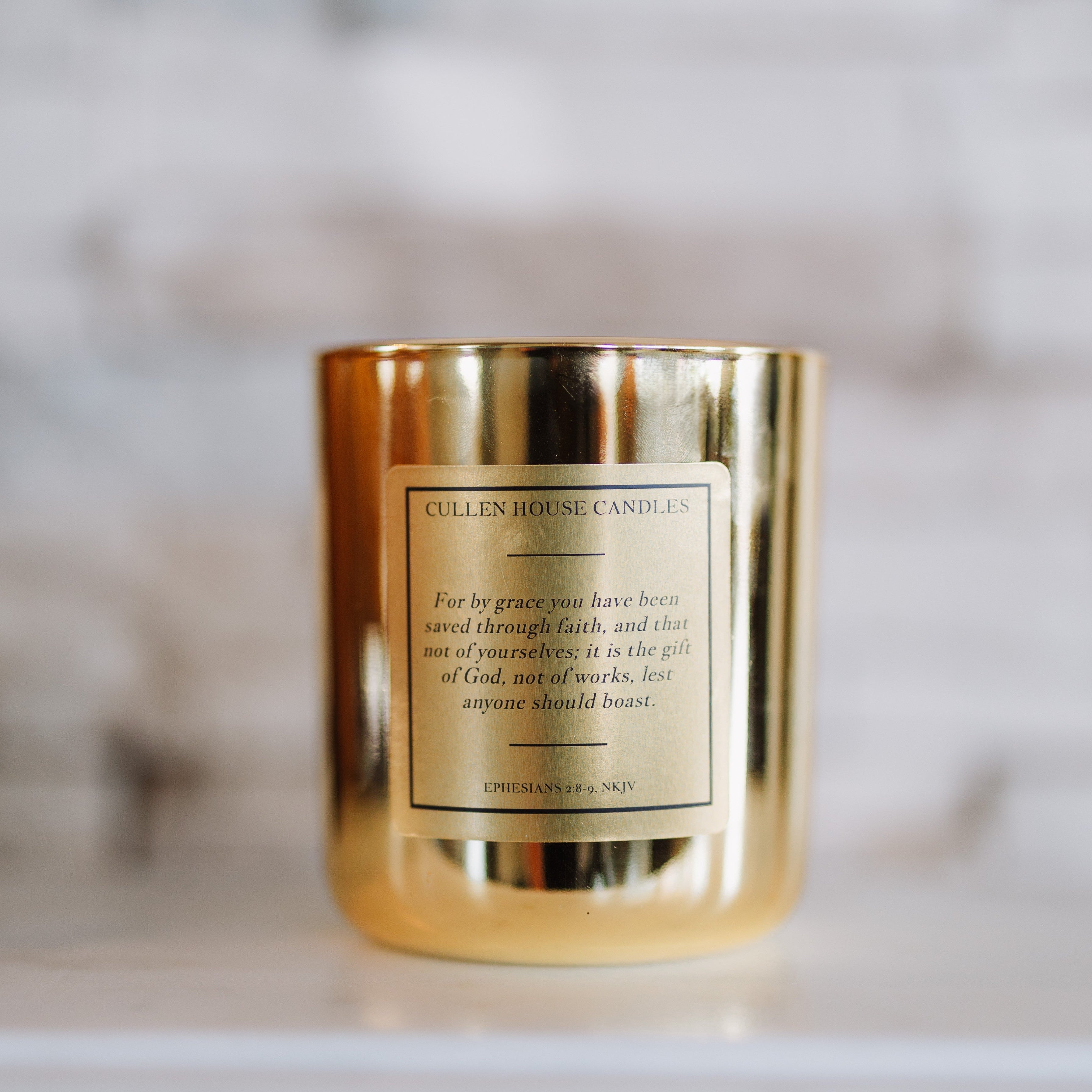 Gold candle with a label on a blurred background