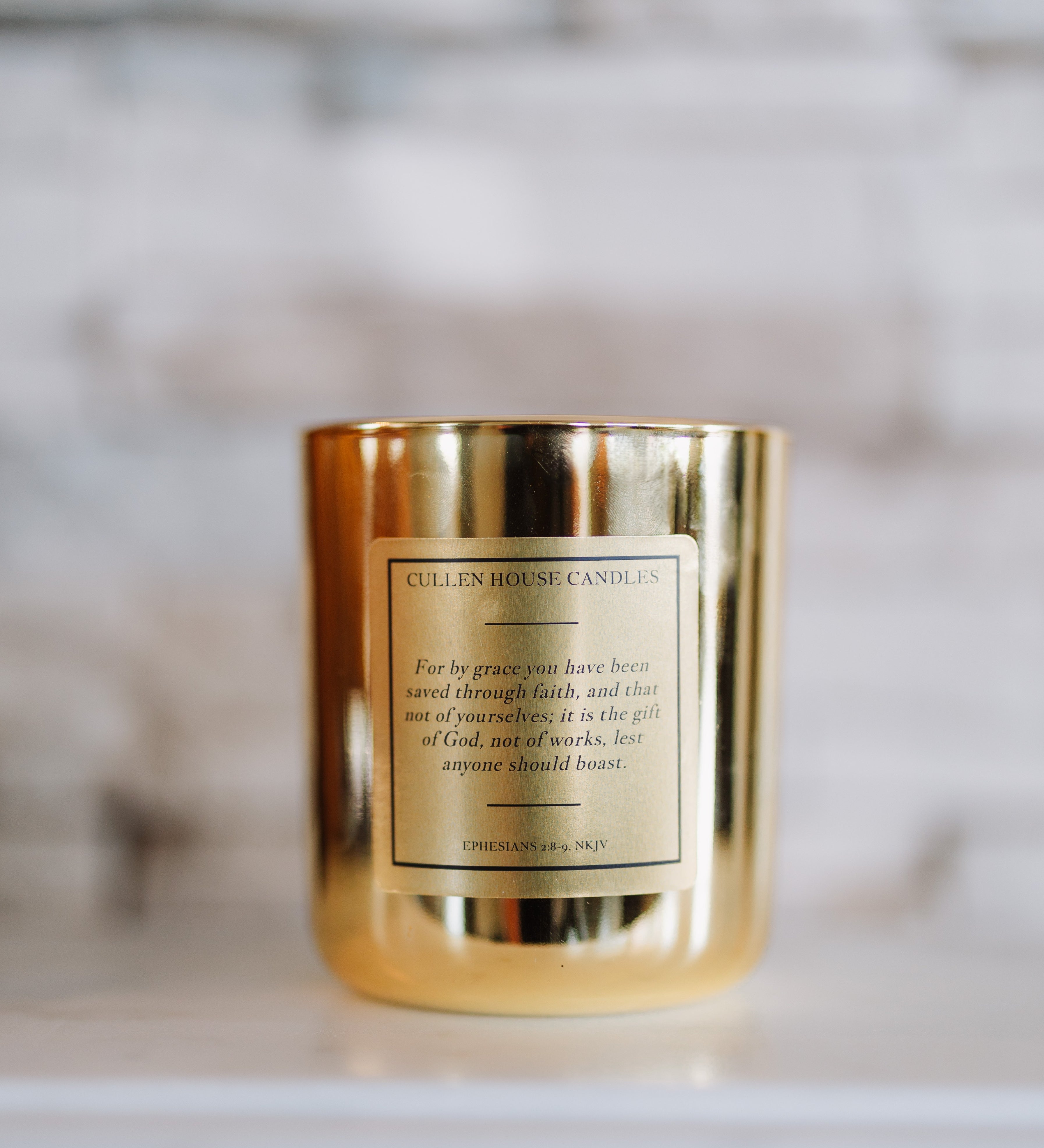 Gold candle with a label on a blurred background