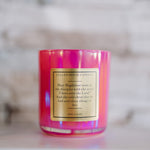 Pink candle with a label on a blurred background