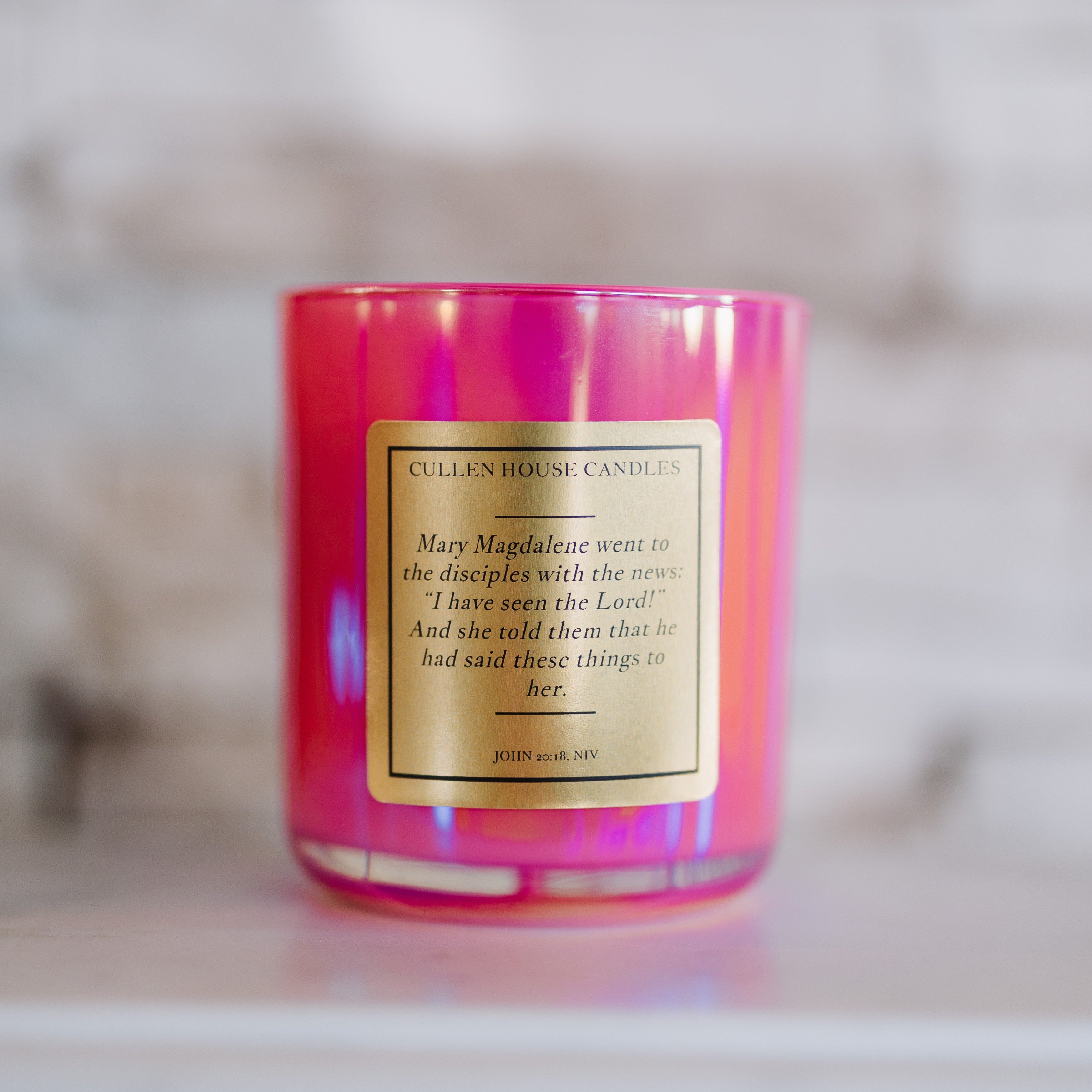 Pink candle with a label on a blurred background