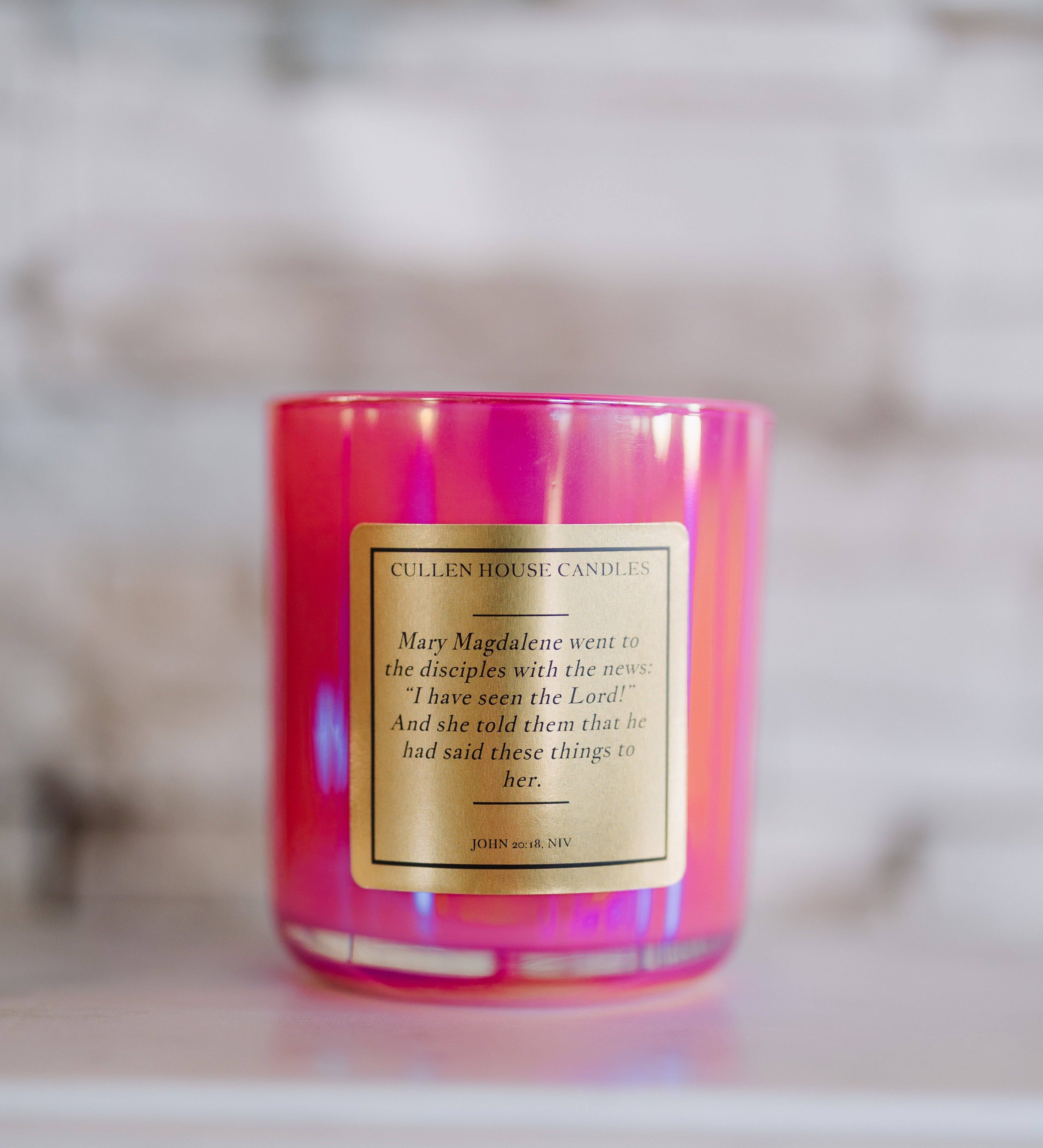 Pink candle with a label on a blurred background