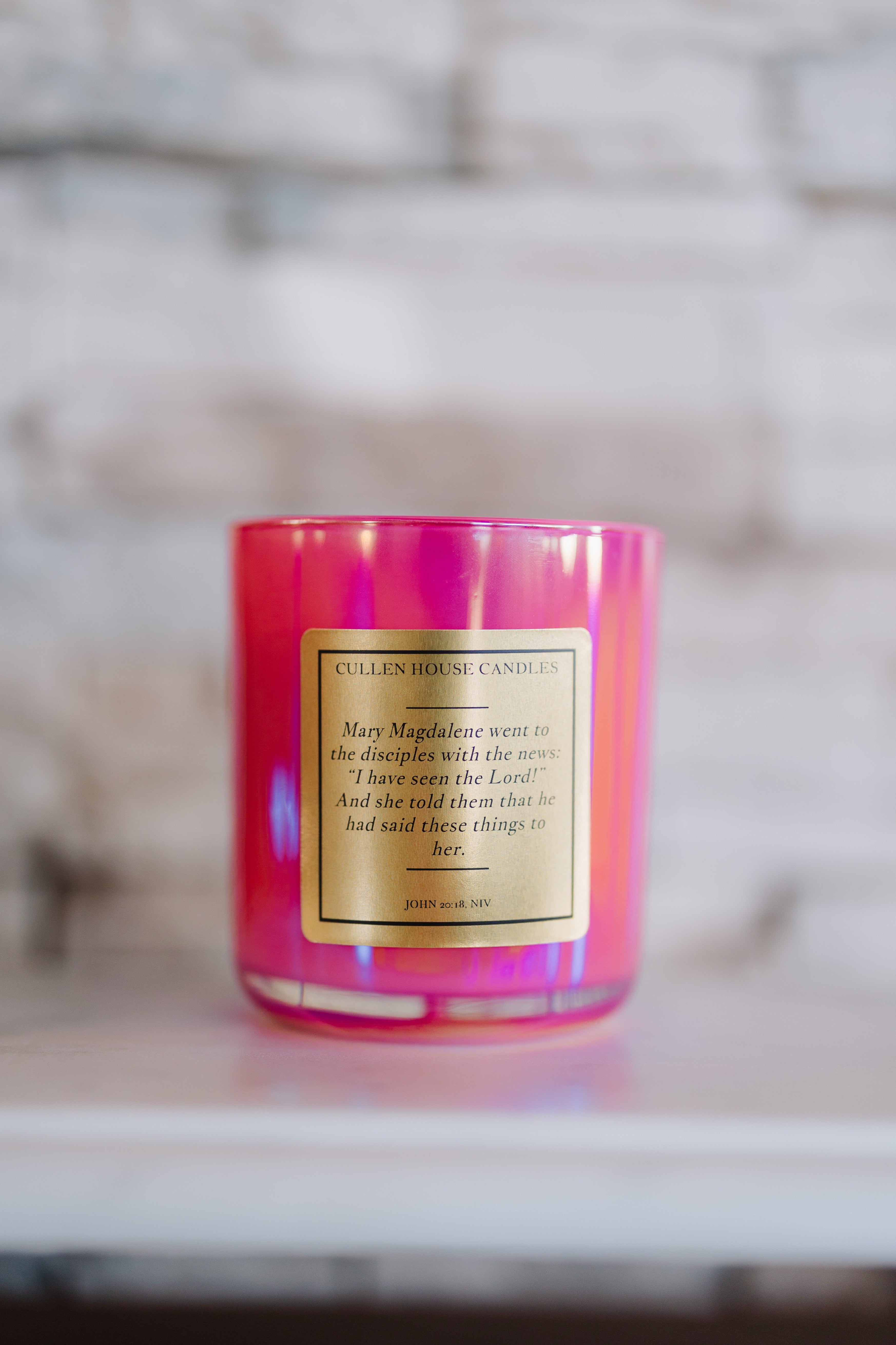 Pink candle with a label on a blurred background