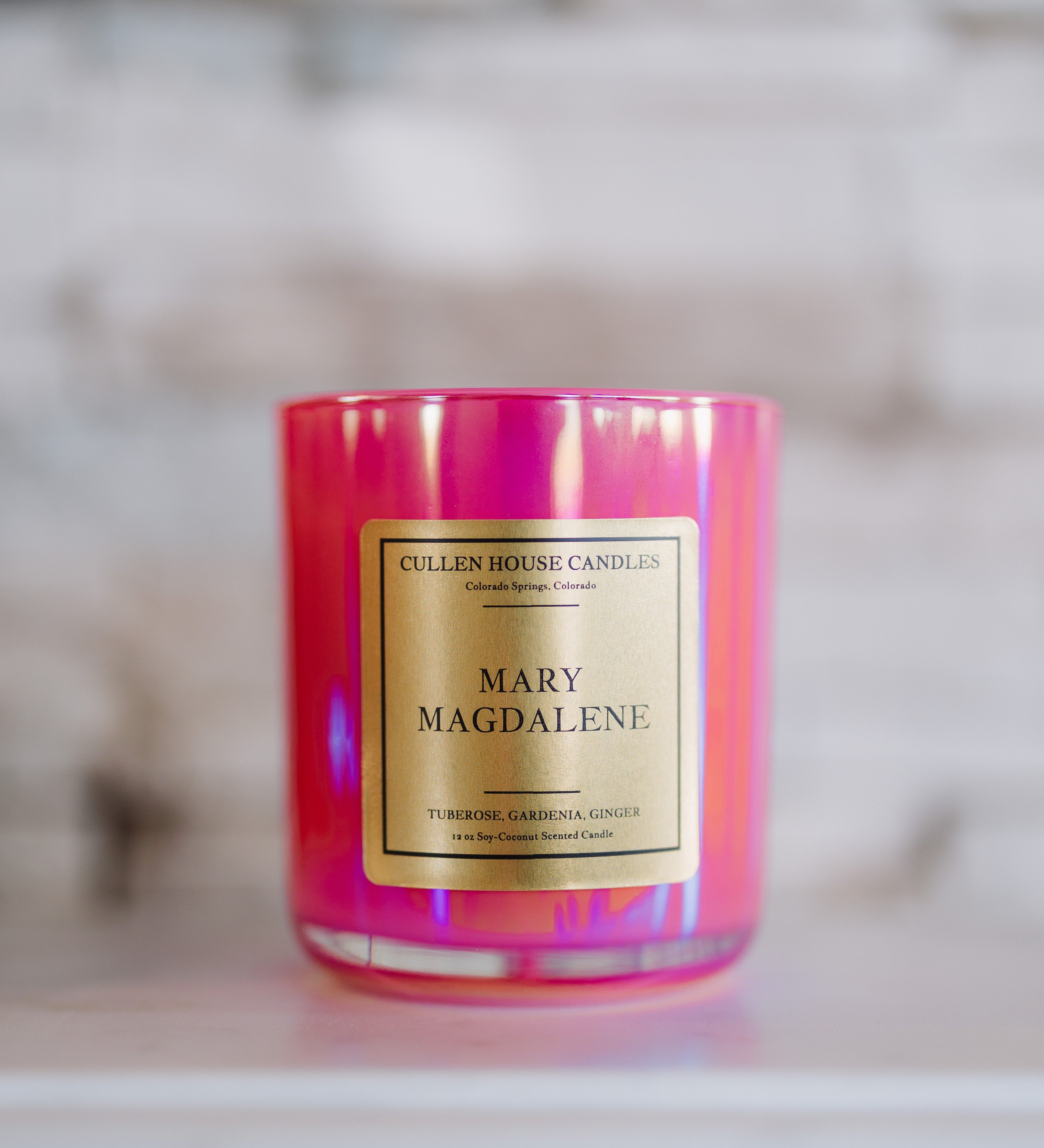 Candle with 'Mary Magdalene' label on a blurred background