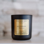 Black candle with a gold label on a marble surface