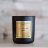 Black candle with a gold label on a marble surface