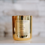 Gold candle with a label on a marble surface