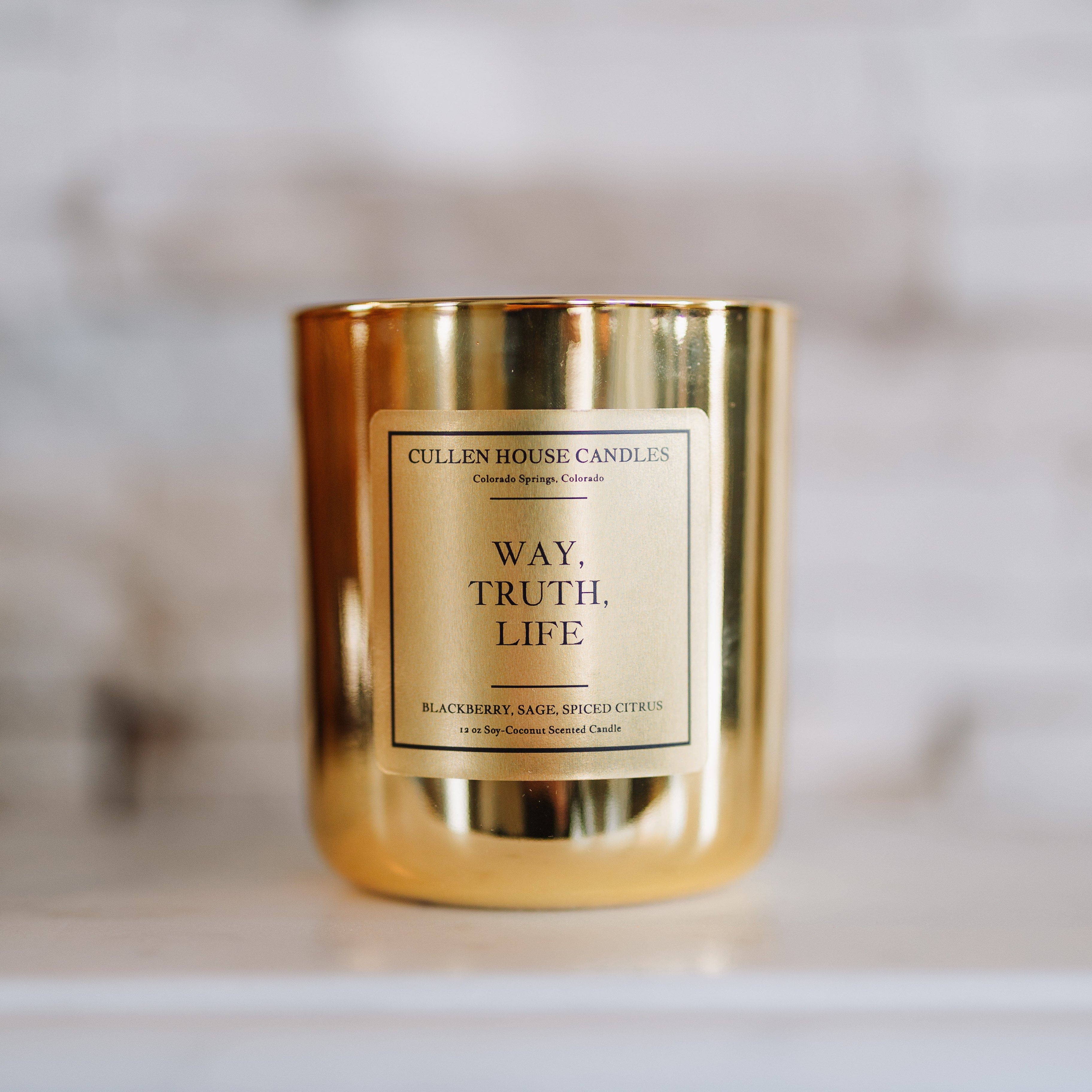 Gold candle with a label on a marble surface