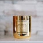 Gold candle with a label on a marble surface