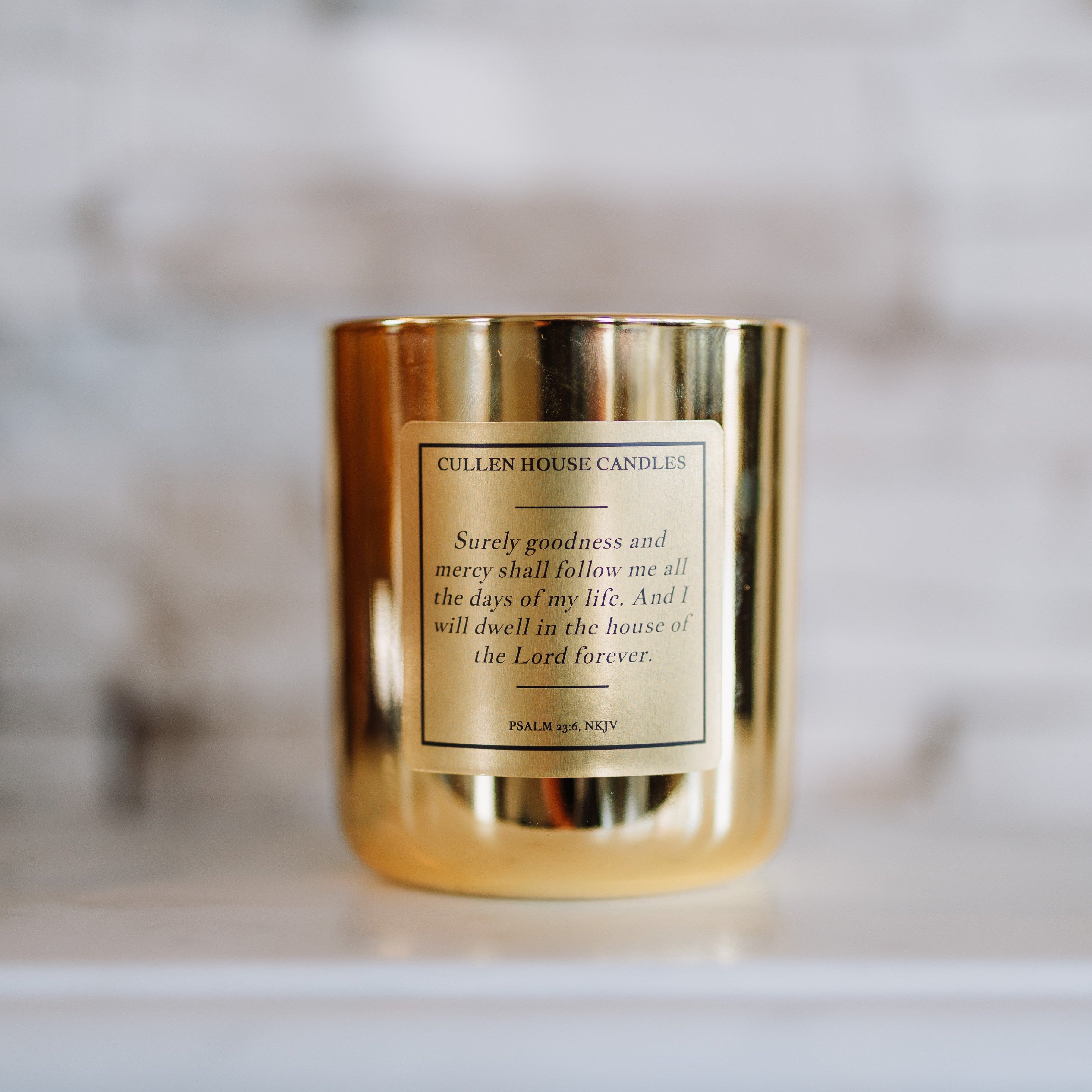 Gold candle with a label on a marble surface