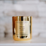 Gold candle with 'House of the Lord' label on a marble surface