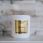 White candle with a gold label on a blurred background
