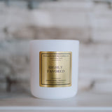 White candle with a gold label on a blurred background